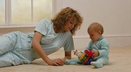 photo of a woman carefully watching her baby